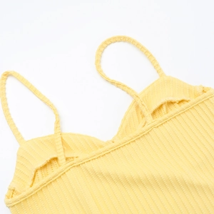 Detailed close-up of the yellow ribbed knit camisole showing shoulder strap craftsmanship
