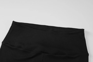 Détail du pantalon de yoga noir en tissu côtelé montrant la taille haute et l'élasticité