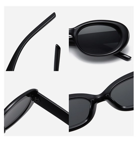 Detail view of oval cat-eye sunglasses featuring metal hinges and smooth black frames