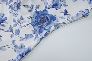 Macro shot showing smooth floral print fabric with blue roses and tight weave texture
