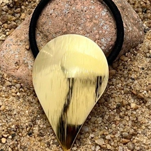 Minimalist golden brushed metal teardrop ponytail holder with black elastic hair tie
