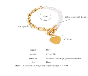 Close-up of heart charm bracelet with gold U-link chain and lustrous shell pearls