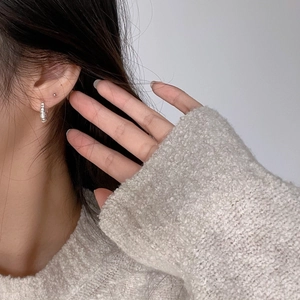 Elegant 925 sterling silver croissant hoop earring worn on ear with minimalist style