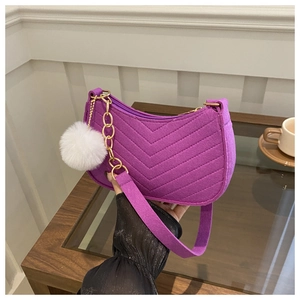 Détail du sac à bandoulière violet à texture en V avec chaîne dorée et pompon blanc