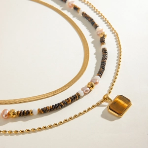 Layered stainless steel necklace set with tiger eye stones and freshwater pearls on gold chains
