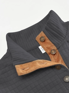 Detail of dark grey quilted jacket with brown suede placket and vintage metal buttons