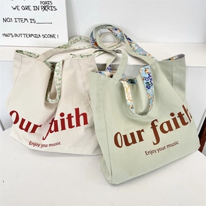 Detail showing canvas tote bags with floral lining and Our Faith printed typography