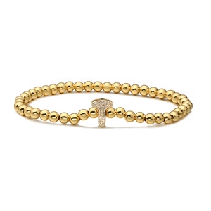 Close-up of golden beaded bracelet featuring a micro-paved zircon letter T charm