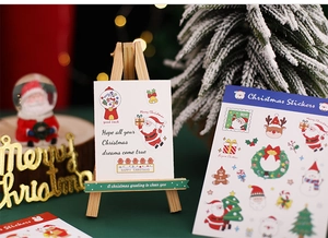 Macro detail of Christmas stickers featuring Santa and reindeer on a mini decorative easel