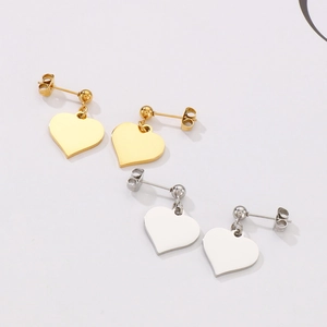 Detailed view of heart-shaped earrings in polished gold and silver stainless steel sets