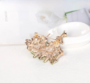 Detail view of the gold alloy back and safety pin clasp on a Christmas tree brooch