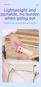 Pink foldable pocket fan being placed in a bag showing compact storage and portability