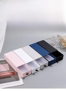 Detailed drawer gift boxes in five colors with textured paper and black ribbon pulls