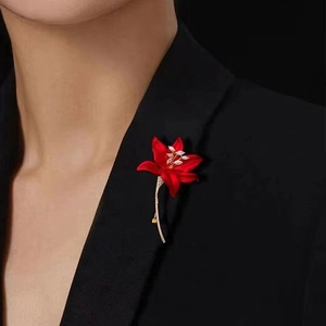 Macro detail of a red flower brooch with gold plating on a black suit lapel