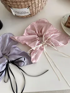 Détail de chouchous nacrés avec nœuds, perles et strass sur une table élégante