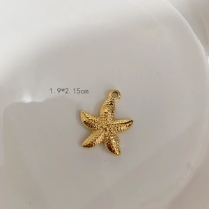 Macro view of a 1.9x2.15cm golden starfish pendant with textured metal surface