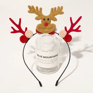 Detail of Christmas reindeer antler headband with plush balls and deer motif decoration