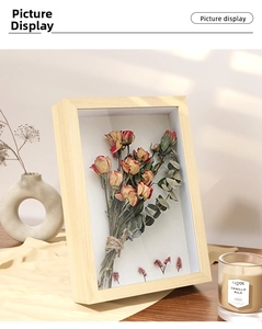 Close-up of 3D shadow box frame featuring dried roses and eucalyptus with wood texture