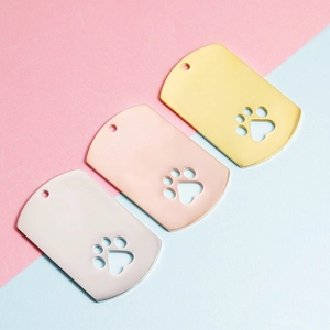 Three mirror-polished dog tags in gold, rose gold and silver with hollow paw prints