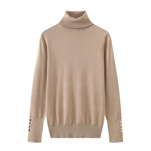 Detailed close-up of beige ribbed knit sweater sleeves with golden button accents