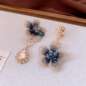 Detailed shot of vintage blue embroidered flower earrings with champagne crystals