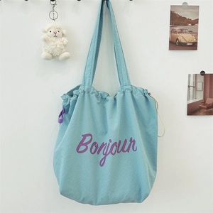 Close-up of light blue checkered nylon tote bag with purple Bonjour script print