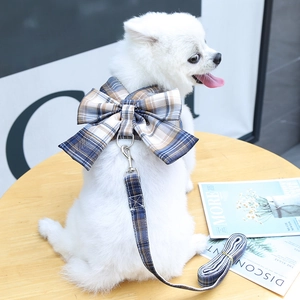 Detailed view of blue and yellow plaid pet harness with a large decorative bow