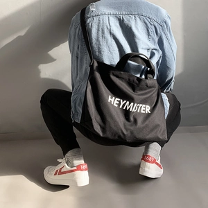 Large black canvas crossbody bag with white HEYMISTER lettering for street style