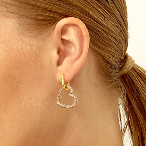 Model wearing gold heart hoop earrings featuring pavé-set purple zircons for a stylish look