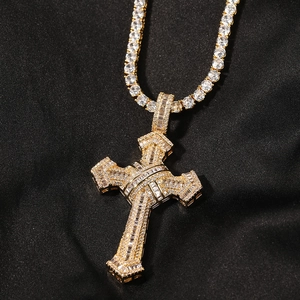 Close-up of gold-plated cross pendant with cubic zirconia on a sparkling tennis chain