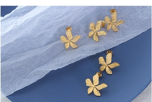 Macro shot of 18k gold plated stainless steel floral earrings with textured petals