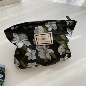 Detail of floral jacquard fabric bag with Pleasant Time label and zipper closure