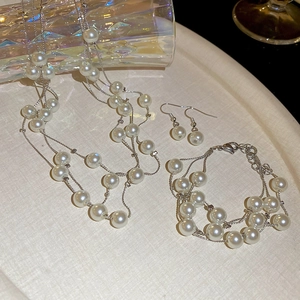 Close-up of elegant multi-layer pearl necklace with silver chain on a tray