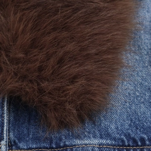 Detail of brown faux fur trim and blue denim fabric texture on a winter jacket