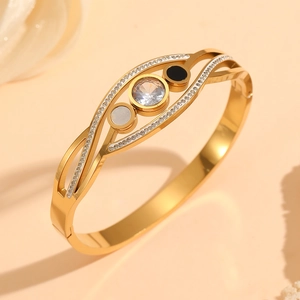 Détail d'un bracelet doré géométrique avec nacre, émail noir et pierres en zircon brillant