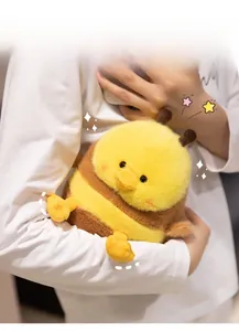 Close-up of a soft plush bee-duck doll held in hands showing fluffy texture and cute size