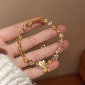 Close-up of adjustable beaded bracelet with yellow crystal and gold lotus charms
