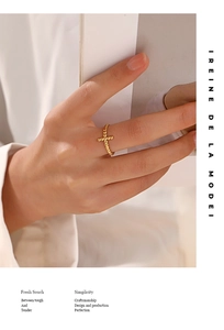 Detail of 18K gold plated beaded ring with cross design worn on model's hand