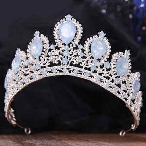 Silver bridal crown with blue teardrop rhinestones on black velvet background