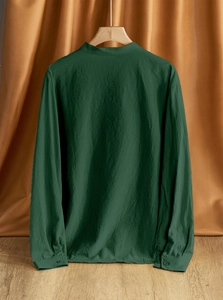 Close-up of a dark green linen shirt featuring natural texture and stand collar