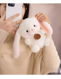 Close-up of soft white plush bunny pendant with cute drooping ears and pink details