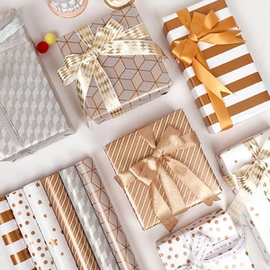 Metallic gold and silver gift wrap paper rolls with patterns and romantic ribbons