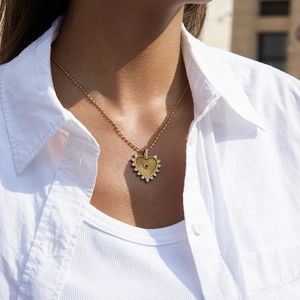 Close-up of 18K gold stainless steel necklace with red heart pendant and diamond accents