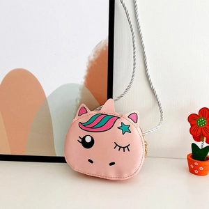 Pink cartoon unicorn crossbody bag for girls with silver woven strap on a cozy background