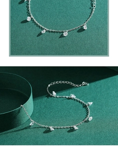 Macro shot of silver anklet with sparkling zircons on a textured green background