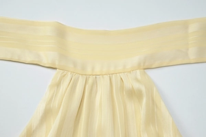 Close-up of yellow backless top showing pleated chiffon texture and ribbed stripe patterns