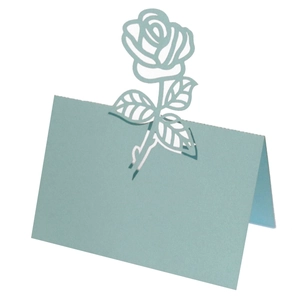 Macro view of light blue laser-cut rose place card with detailed hollow floral patterns
