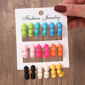 Gros plan de 9 paires de boucles d'oreilles créoles colorées en acrylique sur carte