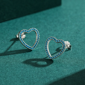 Boucles d'oreilles cœur en argent S925 avec pierres turquoise sur fond vert foncé