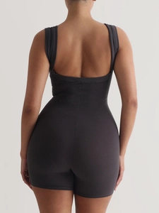 Detail of the back view showing dark grey ribbed yoga jumpsuit with an open-back design